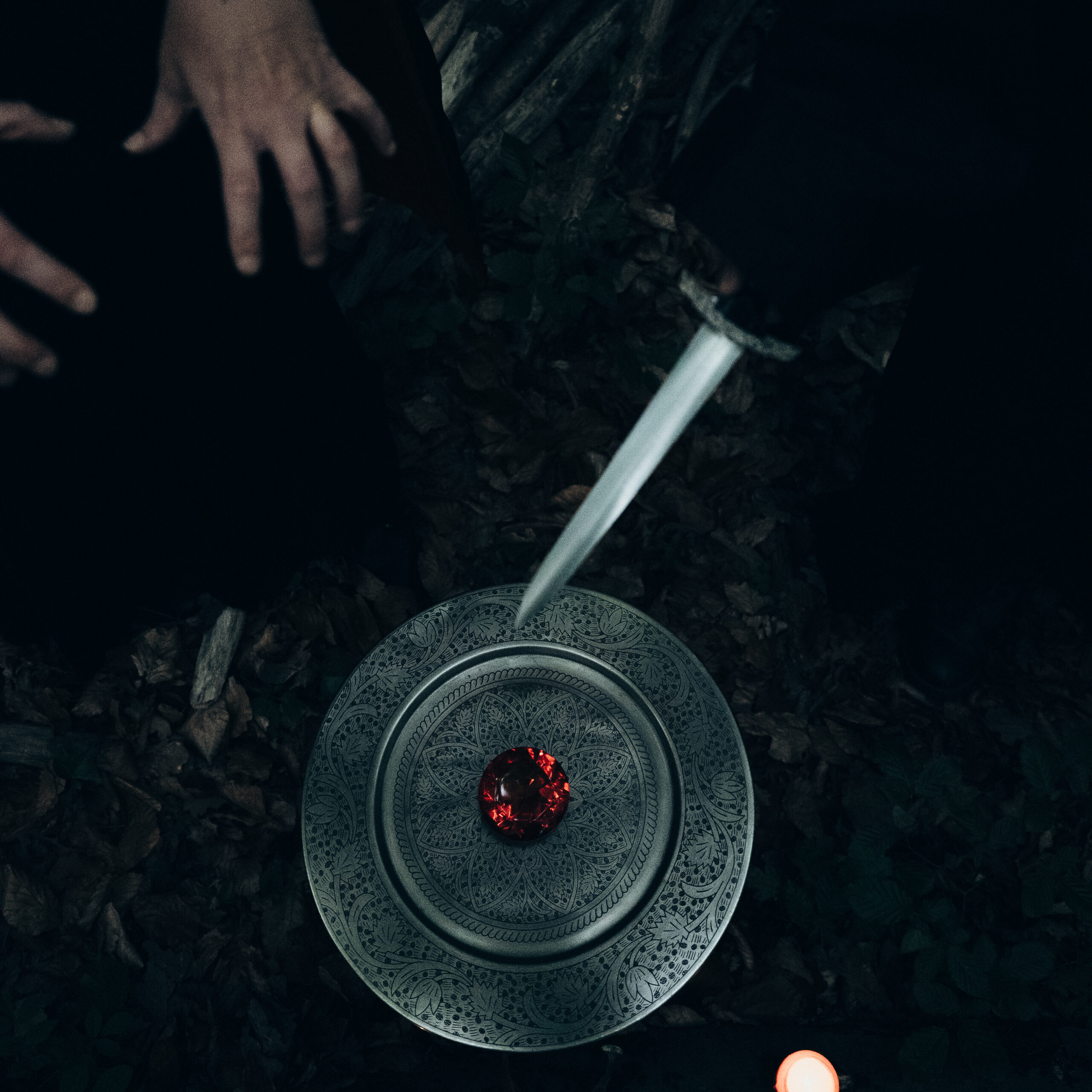 Hände über einem roten Edelstein. Ritual Detailaufnahme